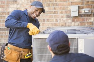 smiling-technician-performs-maintenance-on-an-air-conditioner-outdoor-unit